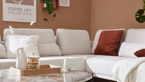 Ein Sofa der Interliving Serie 4450 in Weiß mit roten Kissen